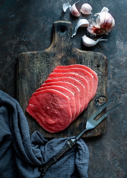 beef raw meat thin slices on dark