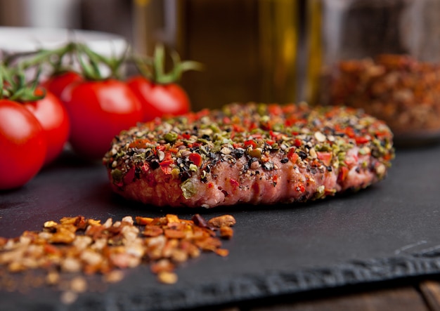 Beef raw steak with pepper and tomatoes on stone board