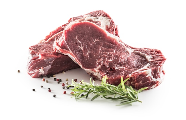 Beef Rib Eye steak with pepper and rosemary isolated on white background.