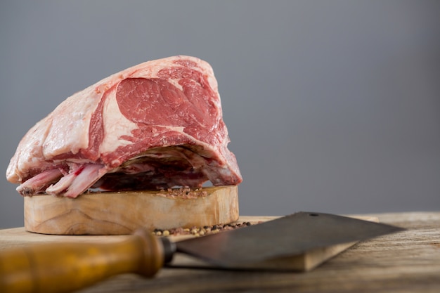 Beef ribs rack and knife on wooden tray against wooden table