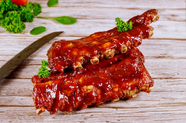 Beef ribs with barbecue and knife on wooden board