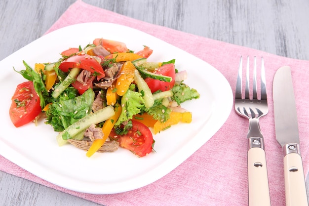 Beef salad on plate on wooden background