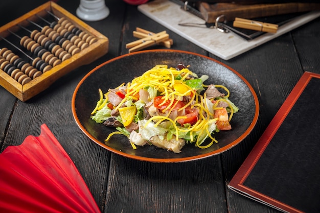 Insalata di manzo con verdure e funghi sul legno nero