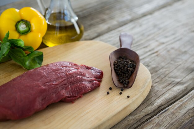 Beef steak and ingredients on wooden tray against wooden table