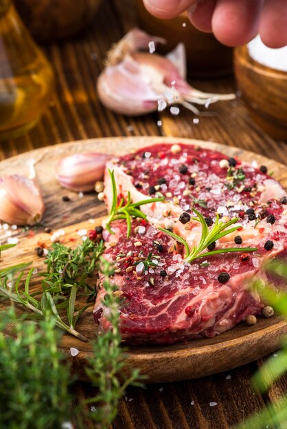 Beef Steak Meat on Wooden Plate with Herbs and Spices