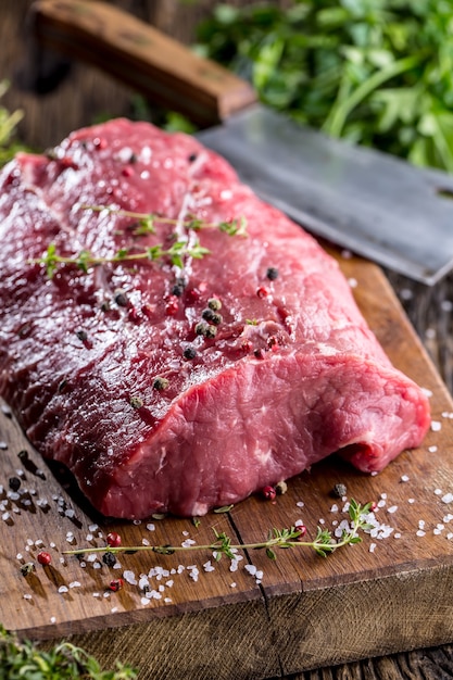 Beef Steak. Raw beef steak. Big Rib Eye steak on wooden board with herb salt and pepper.