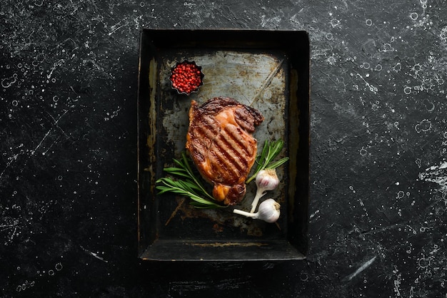 Beef steak ribeye in a metal baking dish Top view Free space for your text