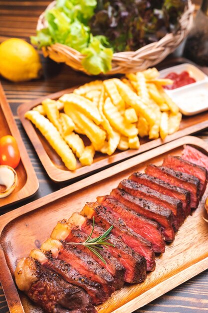 Beef steak serve on wooden plate with rosemary herb and pepper fresh grilled meat food made for dinner picanha or sirloin beef fillet cut with salt and vegetable