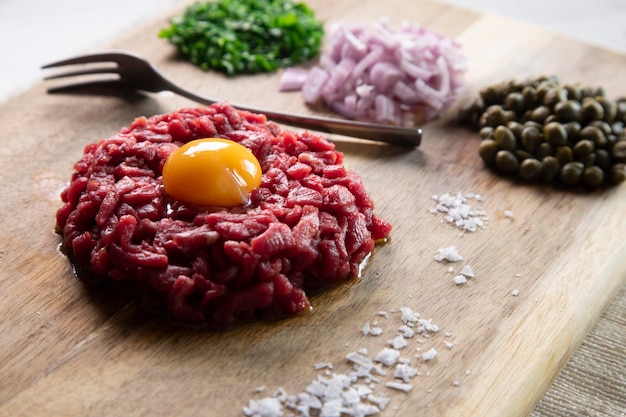 Beef steak tartare with egg and toast.