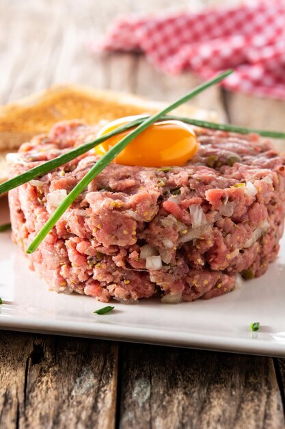 Beef steak tartare on wooden table