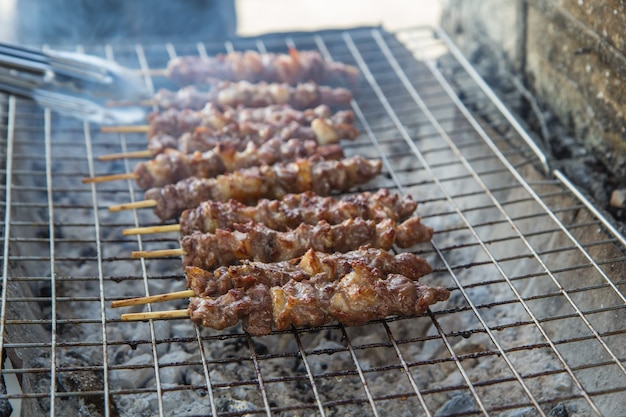 Beef steak 
tongs steel on the grill with flames.