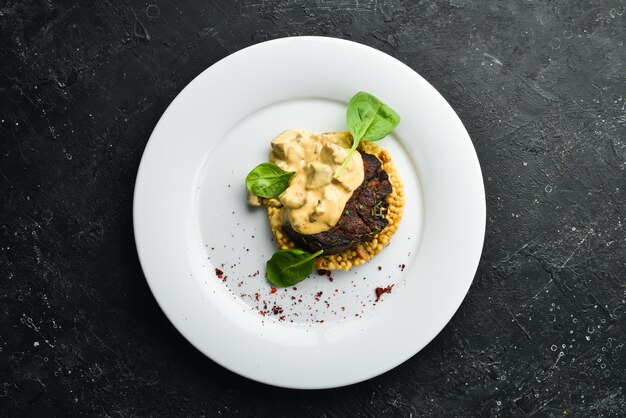 Beef steak with bulgur and mushrooms on a plate Restaurant menu European cuisine