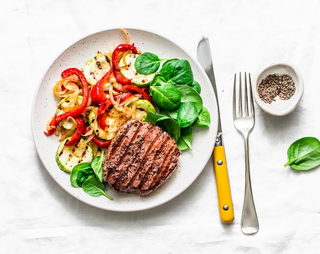 Beef steak with grilled vegetables sweet pepper zucchini and fresh spinach