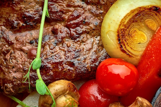 Beef steak with grilled vegetables on a wooden tray