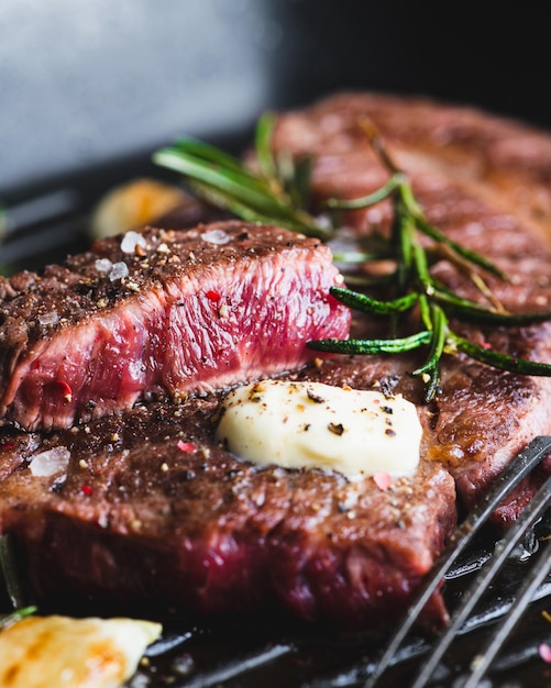 Beef steak with rosemary black pepper sea salt and butter on a grill pan selective focus