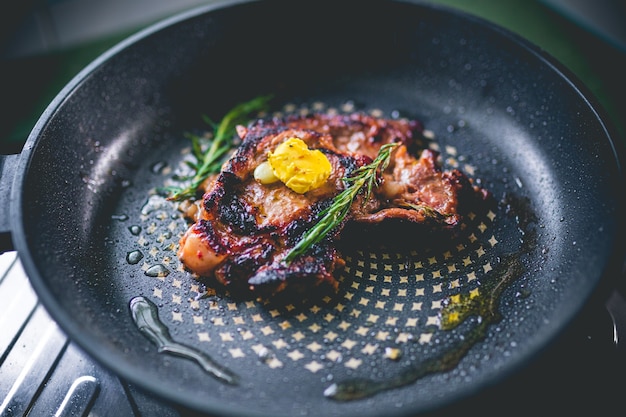 Beef steak with rosemary, garlic, salt and pepper inside iron skillet