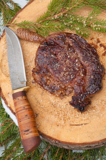 Beef steak with sea salt on a wooden saw