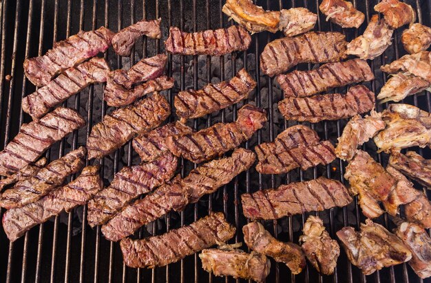 쇠고기 스테이크와 닭고기가 그릴에 튀겨집니다.