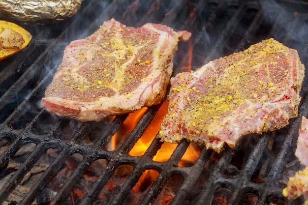 Beef steaks on the grill with flames