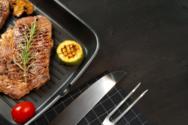 Beef steaks with vegetables on grill pan