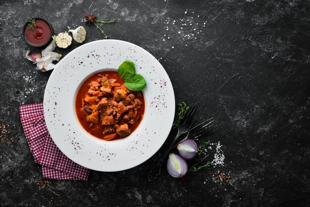 Beef stew with beans and vegetables in a tomato sauce on a plate Top view Free copy space