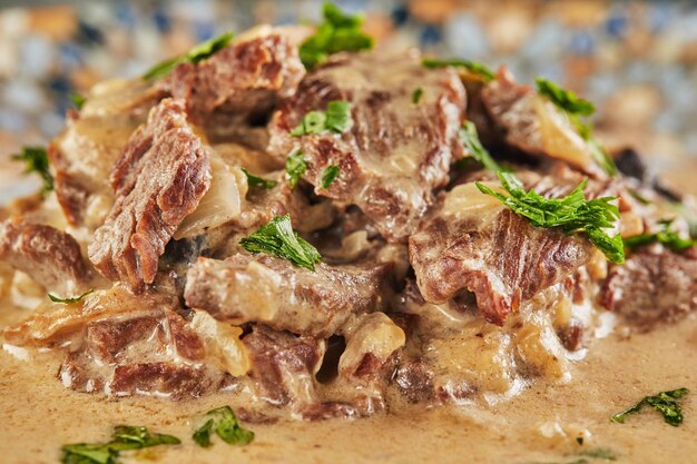 Beef stroganoff on a plate and eating utensils. French gourmet cuisine