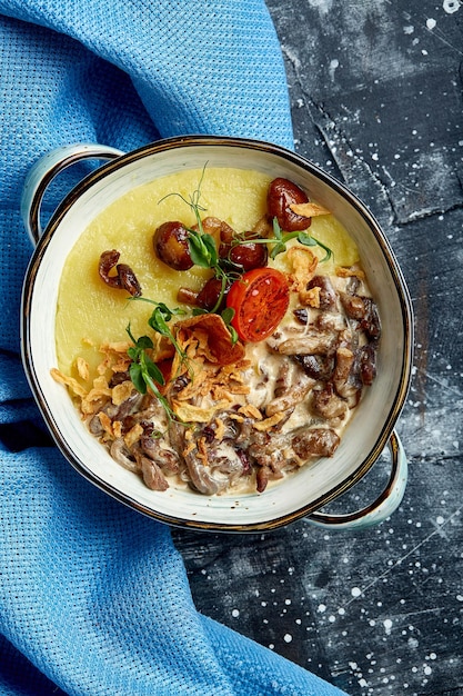 Beef stroganoff with mashed potatoes in a pot top view stone background