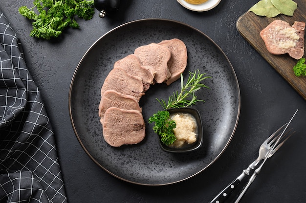 사진 블랙 테이블에 와사비 소스와 로즈마리 장식을 제공하는 쇠고기 혀