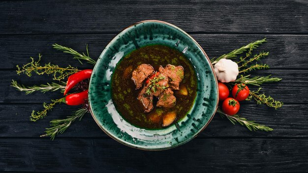 Beef and Vegetable Soup Top view On a black wooden background Copy space