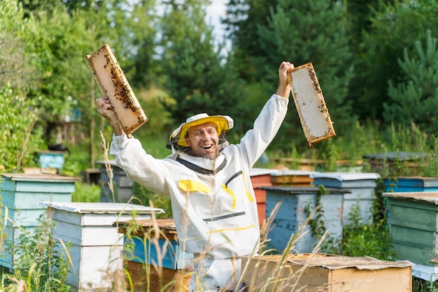 写真 養蜂家は養蜂場でミツバチと協力します