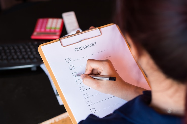 Foto beeld van businessfemale die controlelijst voorbereiden bij bureau