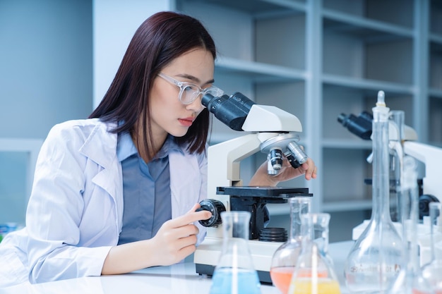 Beeld van jonge Aziatische vrouw die in het laboratorium werkt