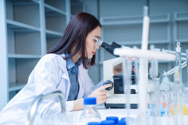 Beeld van jonge Aziatische vrouw die in het laboratorium werkt