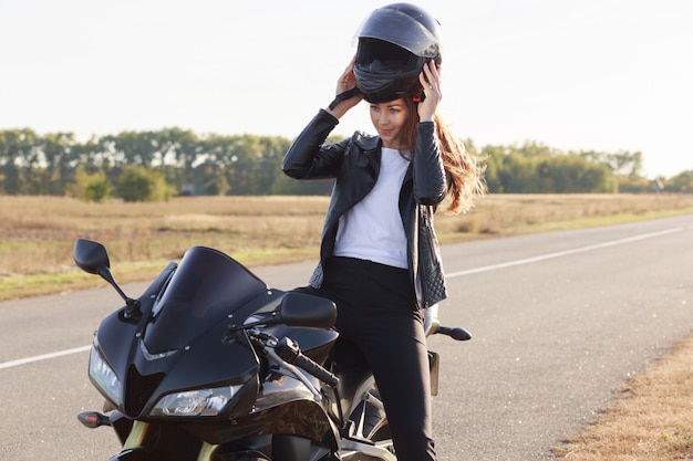 Beeld van mooie slanke jonge risiconemerzitting op haar motorfiets