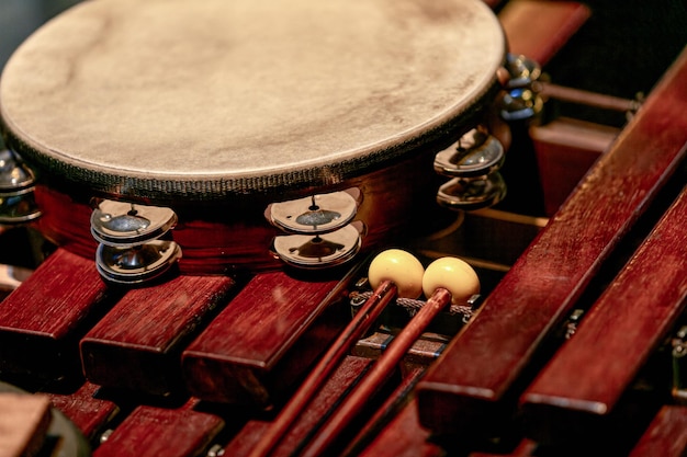 Beeld van tamboerijn en trommelstokken op een houten xylofoon