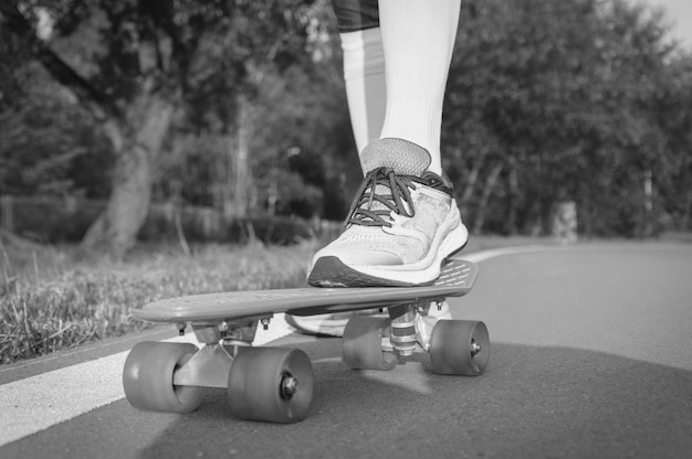 Beelden van een been dat op een skateboard staat. Zonnige avond in het park. Skateboarden concept. Gemengde media