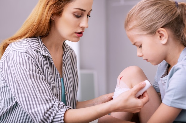 Beenblessure. depressief ongezellig meisje dat naar haar keek terwijl ze naast de verpleegster zat