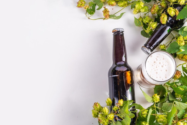 Photo beer bottle and glass with hop cones