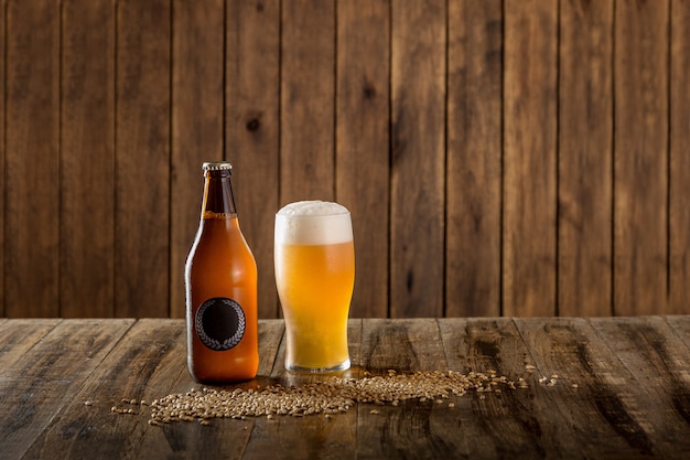 Beer bottle and glass on wooden background