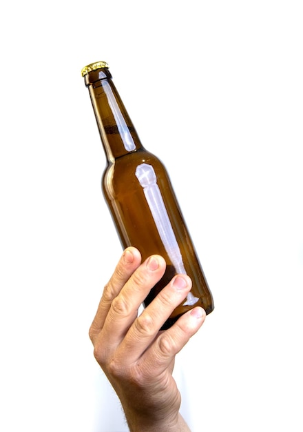 Beer bottle in hand isolated on white