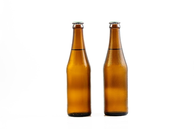 白い背景の上のビール瓶白い背景で隔離の滴とビールのボトル
