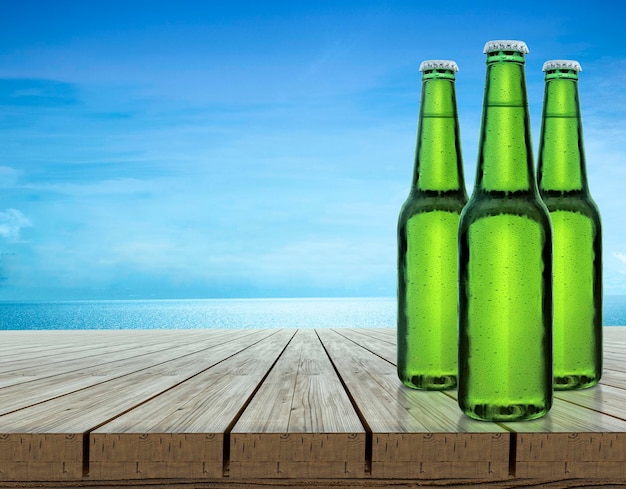 Beer bottle with water drops on indigo wood table top and blue background Products can be placed or cut for display concept beach and summer