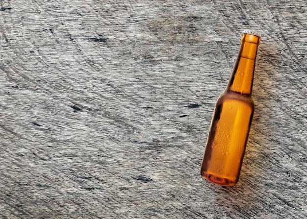 Beer bottle on wooden board turf closeup Top view