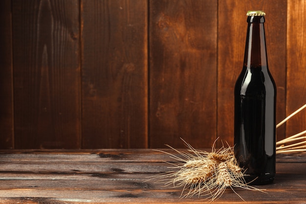 Beer bottle on wooden wall with copyspace