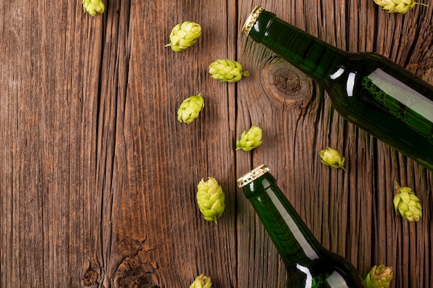 Beer bottles and hops on wooden background