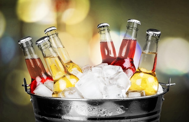 Photo beer bottles in ice on light background