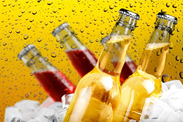 Photo beer bottles in ice on wet glass background
