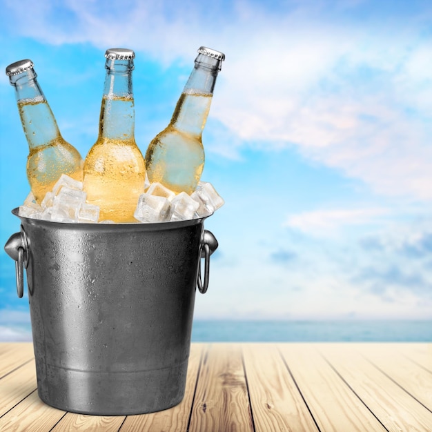 Beer bottles with ice on light background