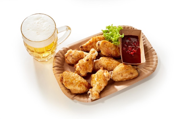 Beer and chicken wings on table