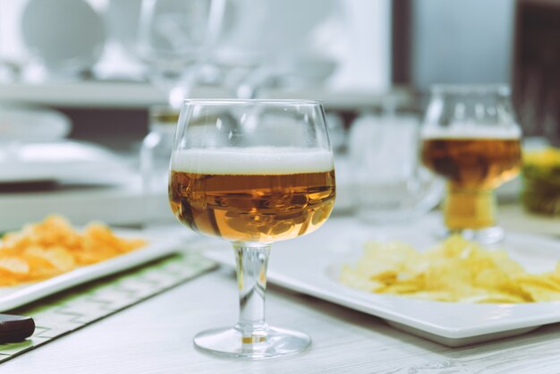 Beer and chips on a large white table